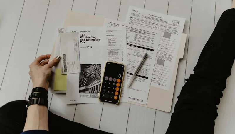 Tax documents and calculator on a home desk